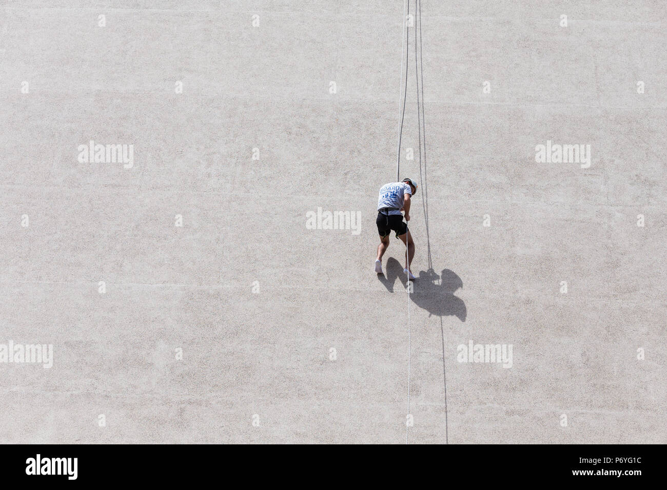 Man Klettern, graue Wand auf sonnigen Sommertag Stockfoto