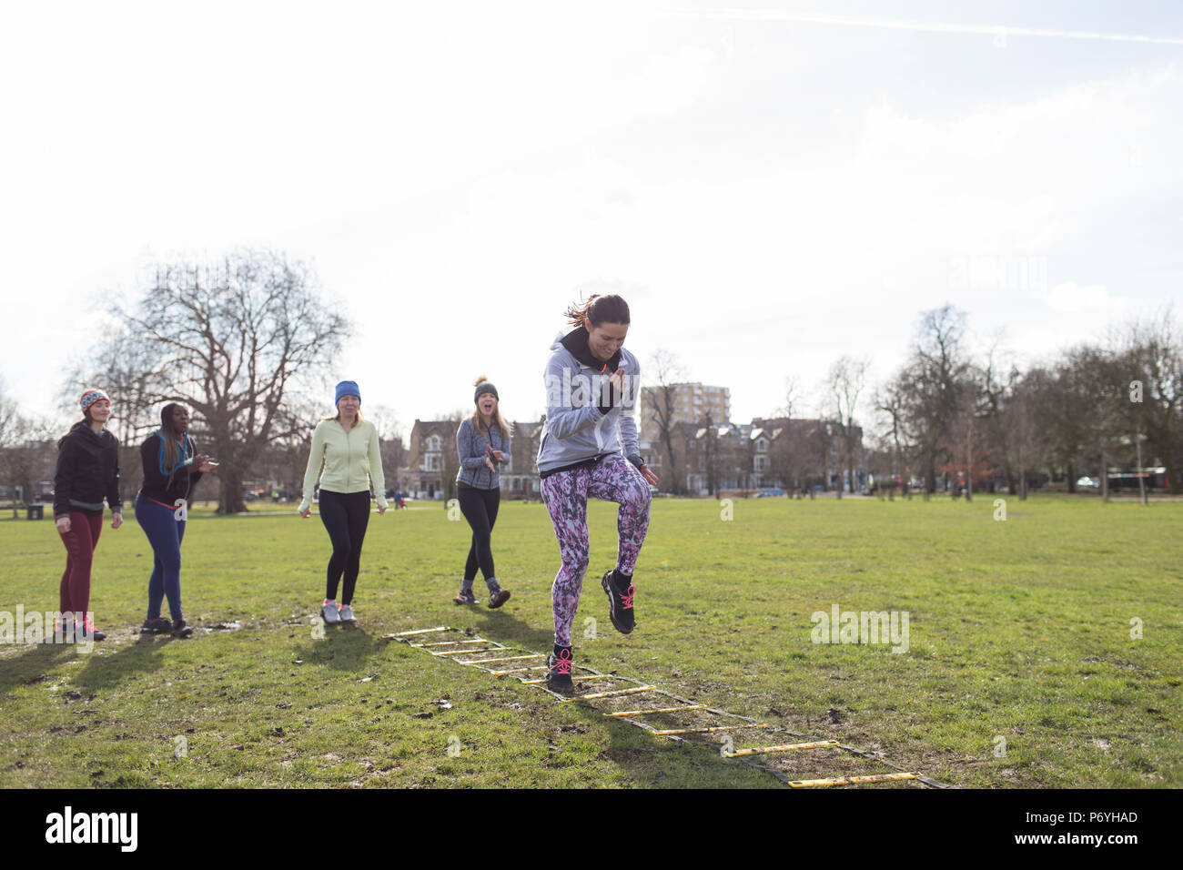 Konzentrierte sich Frau tun Geschwindigkeit Leiter Bohren im sonnigen Park Stockfoto
