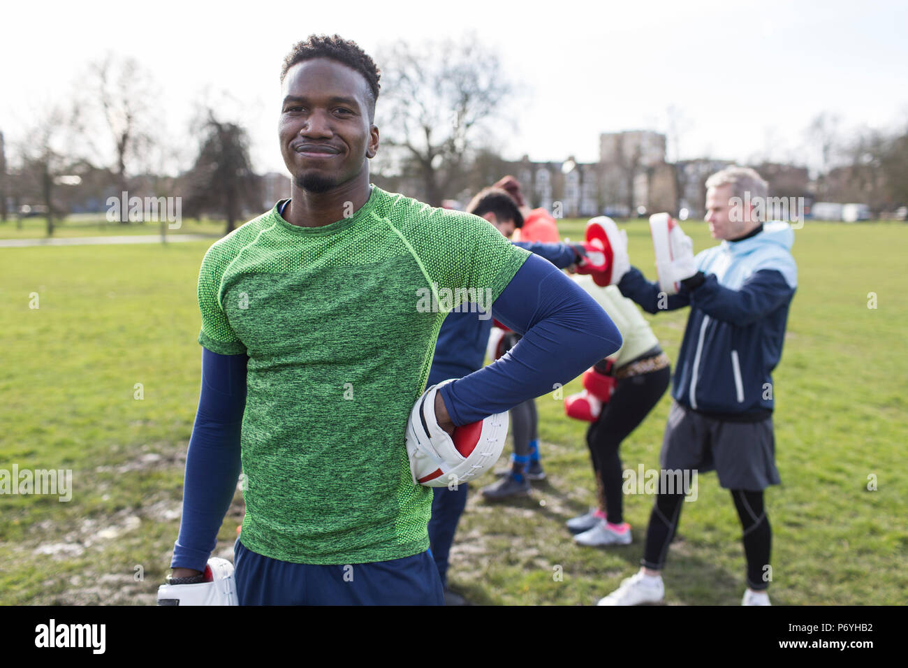 Portrait selbstbewussten jungen Mann Boxen im Park mit Freunden Stockfoto