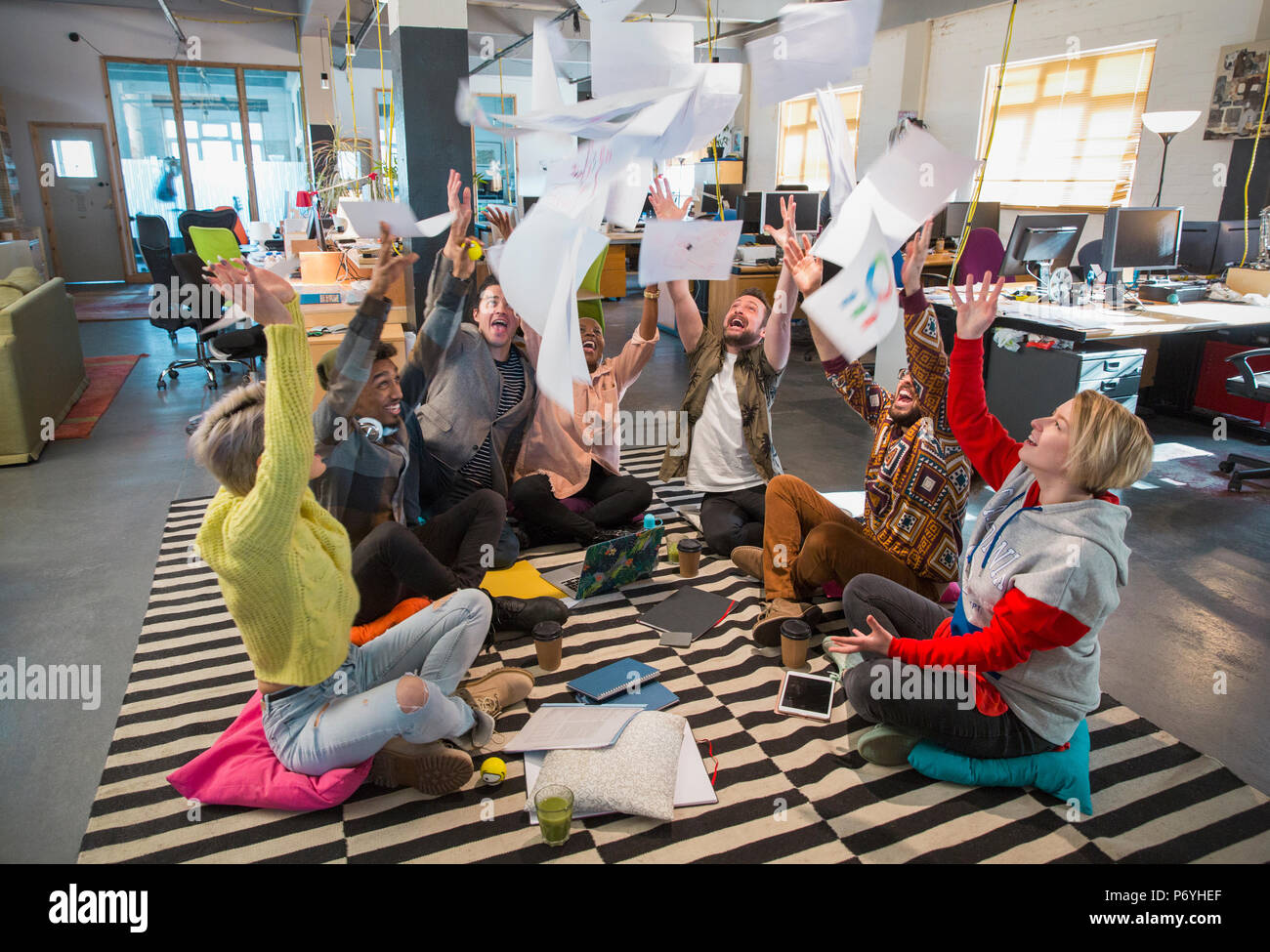Verspielt, romantisch Creative Business Team werfen Schreibarbeit Overhead im Großraumbüro Stockfoto