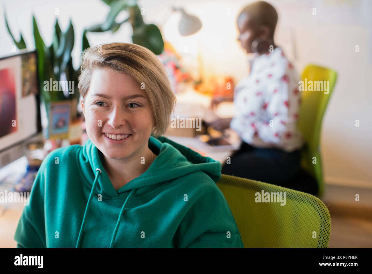 Lächelnde kreative Geschäftsfrau im Büro Stockfoto
