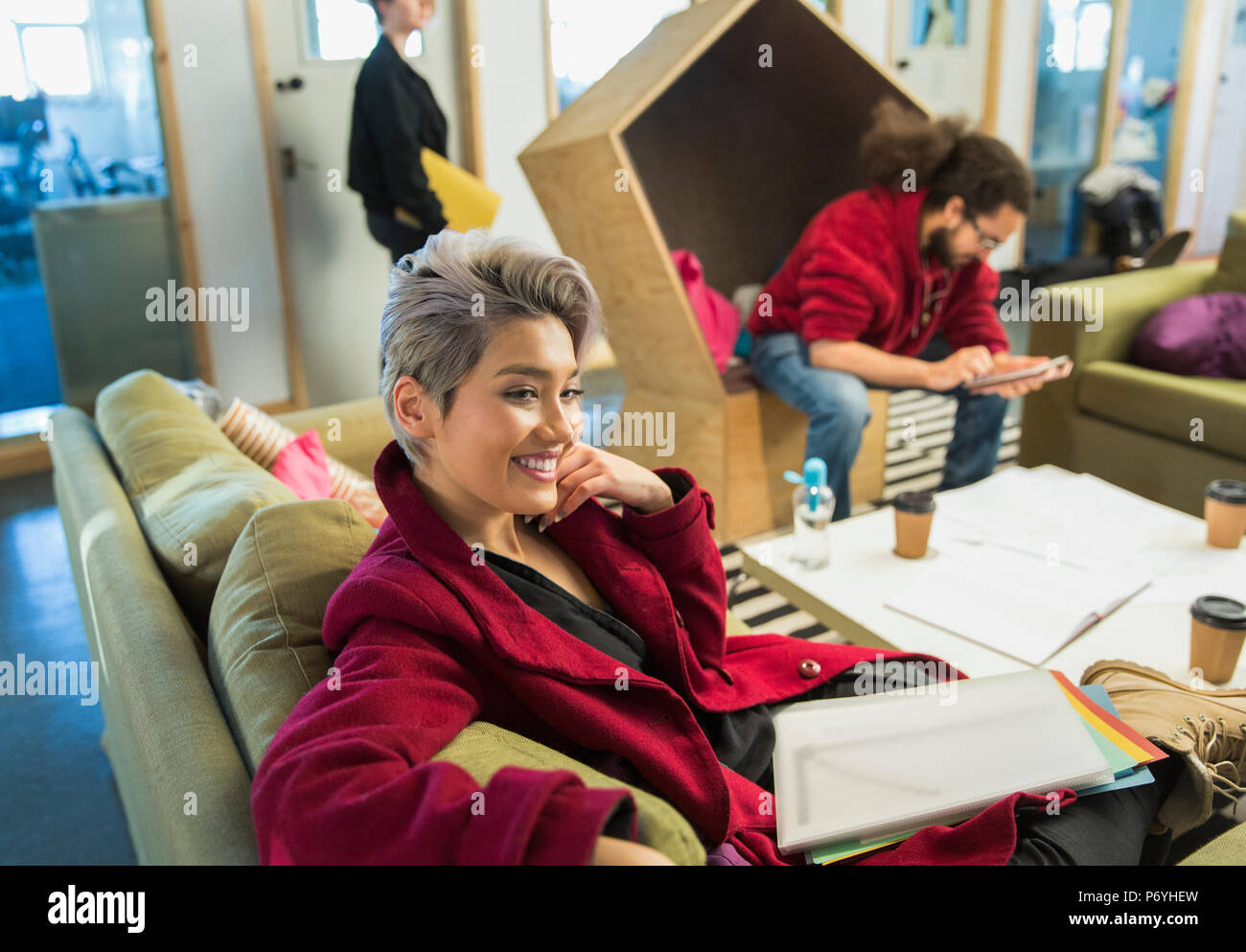 Lächelnd kreativen Geschäftsfrau mit Papierkram in lässig-Büro Stockfoto