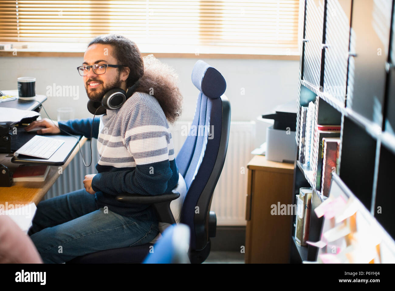 Porträt Lächeln, zuversichtlich, dass kreative Unternehmer mit Kopfhörern arbeiten im Büro Stockfoto