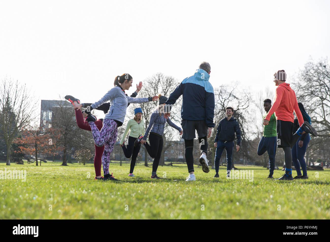 Leute trainieren, Stretching im sonnigen Park Stockfoto