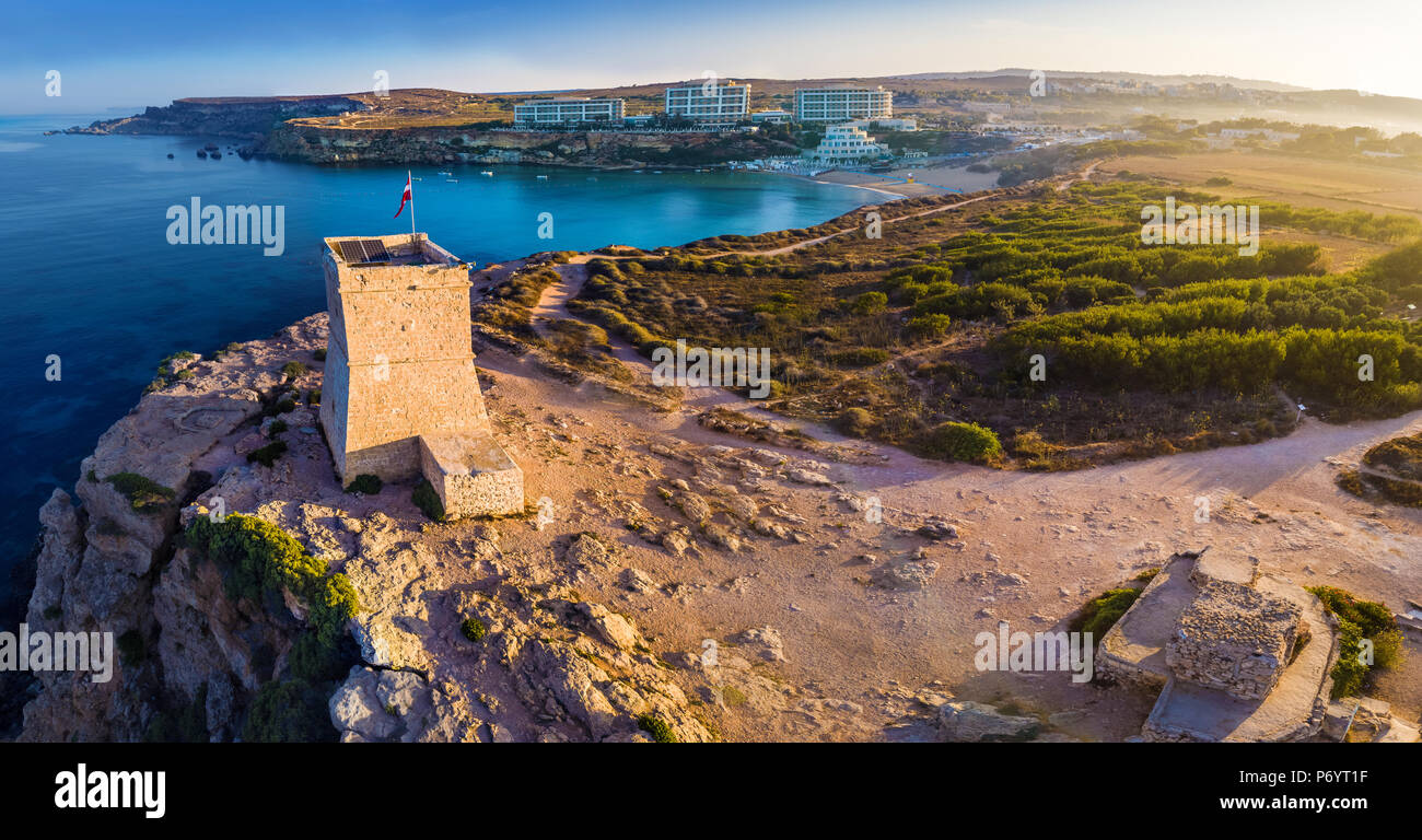 Ghajn Tuffieha, Malta - Luftbild Panorama von Ghajn Tuffieha Watch Tower mit Golden Bay Strand und das kristallklare Meer bei Sonnenaufgang Stockfoto