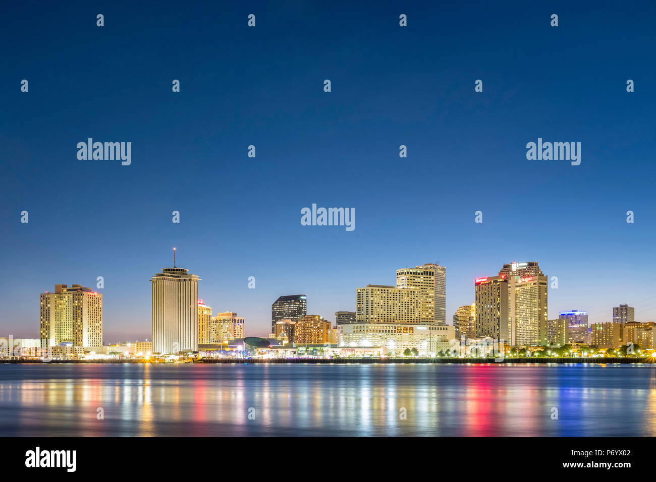 Usa, Louisiana, New Orleans. Blick auf die Skyline der Innenstadt von New Orleans aus über dem Mississippi River in der Abenddämmerung. Stockfoto