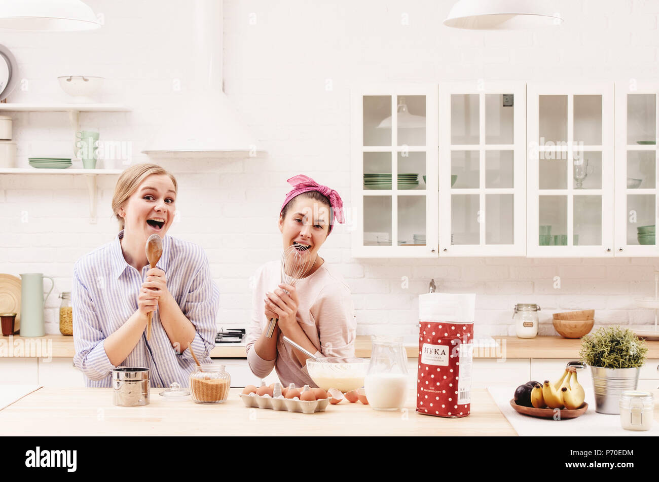 Zwei Fröhlichen Freunden gemeinsam kochen Desserts und Singen. Stockfoto