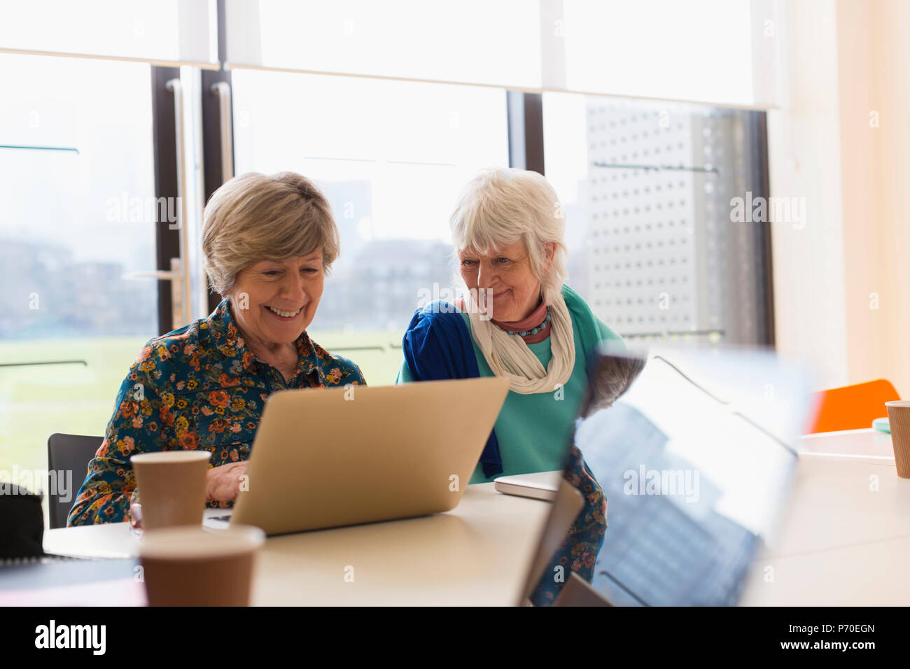 Senior Unternehmerinnen mit Laptop in Sitzung Stockfoto
