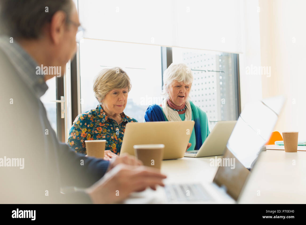 Senior Unternehmerinnen mit Laptops im Konferenzraum treffen Stockfoto