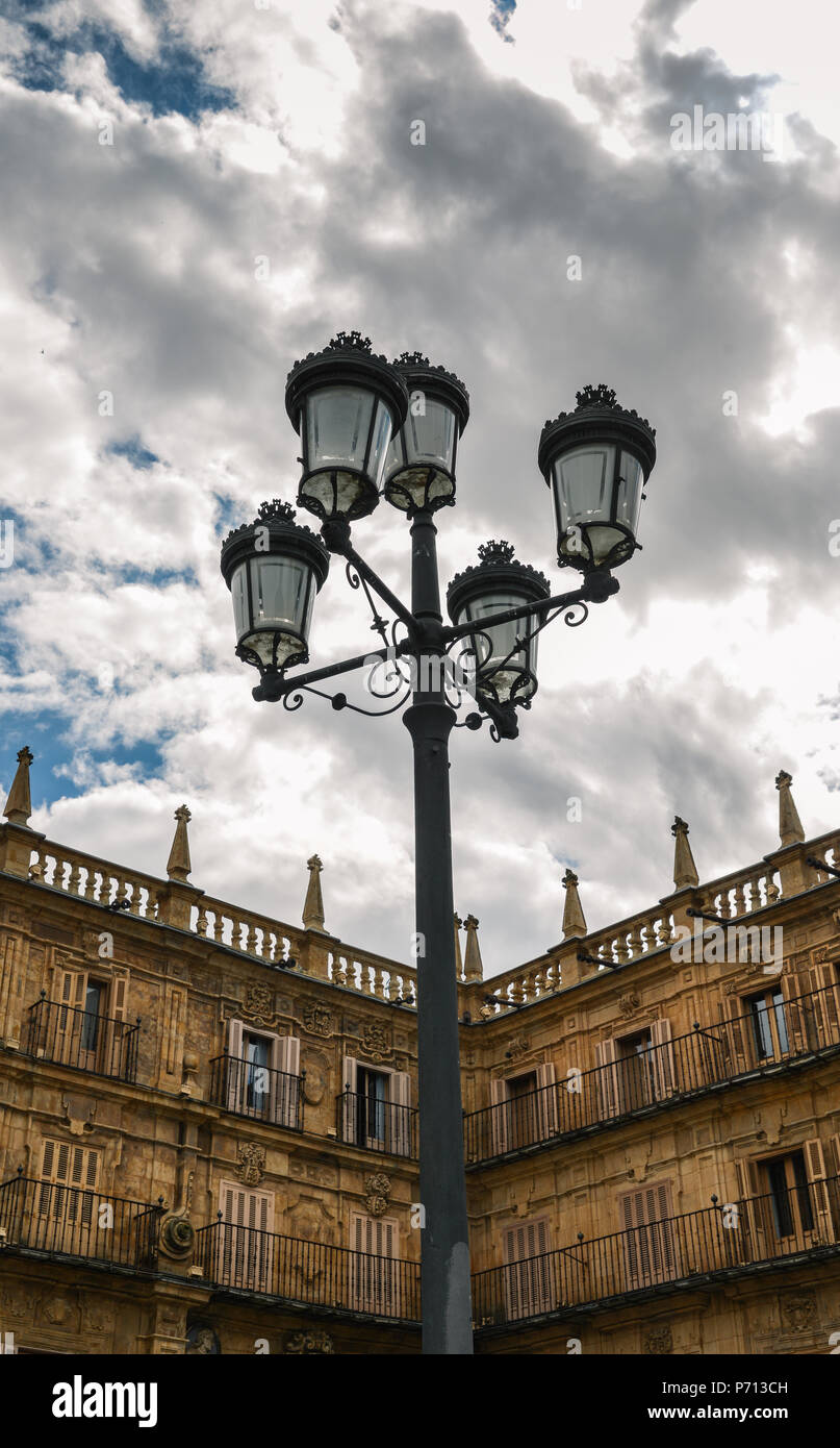 Traditionelle Straßenleuchte auf der berühmten und historischen Plaza Mayor in Salamanca mit dramatischen Wolken, Castilla y Leon, Spanien - UNESCO. Stockfoto