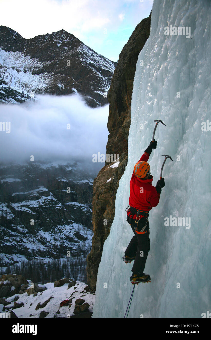 Ein Eiskletterer macht seinen Weg auf einem gefrorenen Wasserfall in der Nähe von Cogne, über das Aosta-Tal, Nord-Italien, Europa Stockfoto