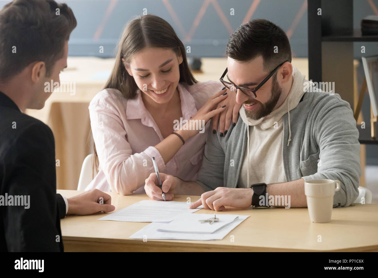 Aufgeregt Paar unterzeichnen Kaufvertrag in Realtor Büro Stockfoto