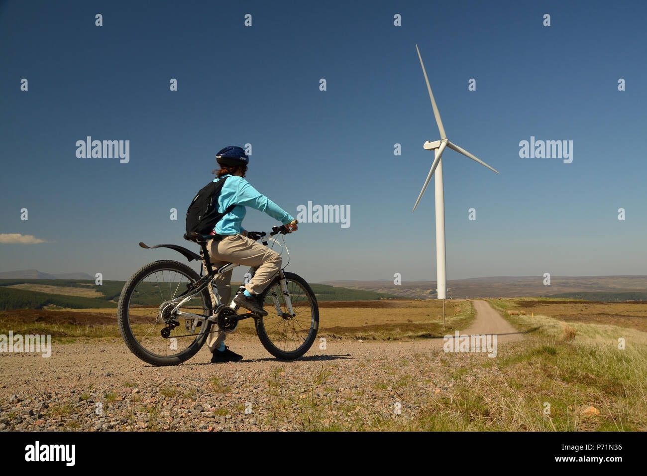 Ein Radfahrer geniessen den Blick aus einem Track in einem Windpark in den schottischen Highlands. Stockfoto