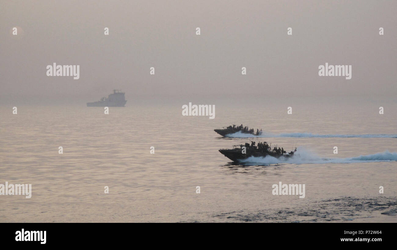 Arabischen Golf (14. Mai 2013) U.S. Navy riverine Befehl Boote aus Riverine Squadron (RIVRON) 2 Patrouille den Persischen Golf als der Royal Fleet Auxiliary amphibische Landung Schiff RFA Cardigan Bay (L 3009) im Hintergrund ist während der Internationalen Mine Gegenmaßnahmen Übung 2013. IMCMEX 13 enthält die Seestreitkräfte aus mehr als 40 Ländern, deren Schwerpunkt ist die regionale Sicherheit durch Mine Countermeasure arbeiten in den USA 5 Flotte Verantwortungsbereich zu fördern. Stockfoto