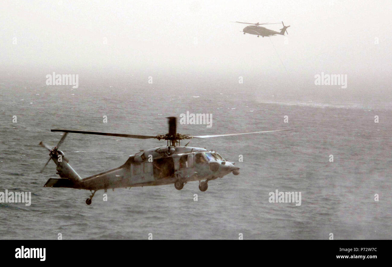 Us-FÜNFTEN FLOTTE VERANTWORTUNGSBEREICH (14. Mai 2013) Der MH-60S Sea Hawk Hubschrauber aus der Wüste Falken der Hubschrauber Meer Combat Squadron (HSC) 26 Tropfen U.S. Navy Taucher in der Nähe von eine fiktive Grube neben dem Flott vorwärts Staging Base (Interim) USS Ponce (AFSB (I) 15) Während ein MH 53E Sea Dragon Hubschrauber von den Blackhawks von Hubschrauber meine Gegenmaßnahmen Squadron (HM) 15 meine Gegenmaßnahme Operationen führt als Teil der internationalen Mine Gegenmaßnahmen Übung 2013. IMCMEX 13 enthält die Seestreitkräfte aus mehr als 40 Ländern, deren Schwerpunkt ist die regionale Sicherheit durch meinen countermea zu fördern. Stockfoto