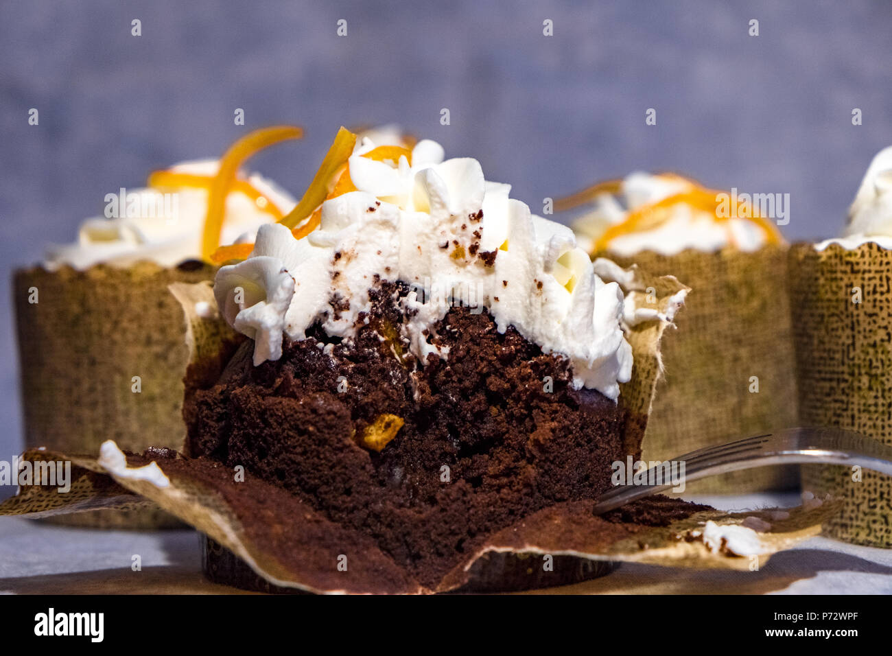 Ein Querschnitt durch eine individuelle Schokolade Kuchen mit kandierten Orangenschalen und Schlagsahne Stockfoto