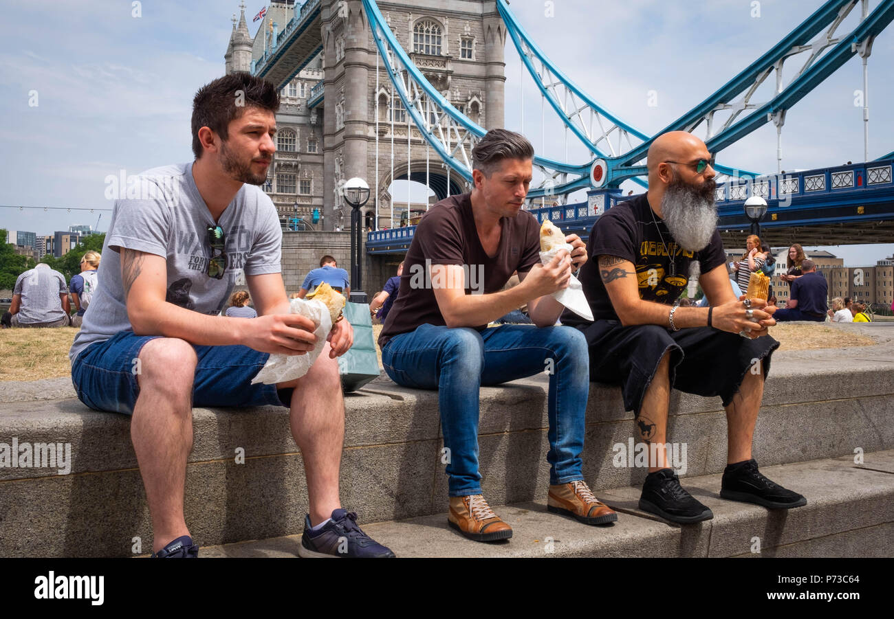 London, England. 4. Juli 2018. Klaus, und Mitul nehmen Zeit aus Ihren ereignisreichen Tag in ihrem Design Company Mittagessen an einem sehr heißen Tag in der Nähe von London, Tower Bridge zu essen. Die derzeitige Hitzewelle wird sich fortsetzen. © Tim Ring/Alamy leben Nachrichten Stockfoto