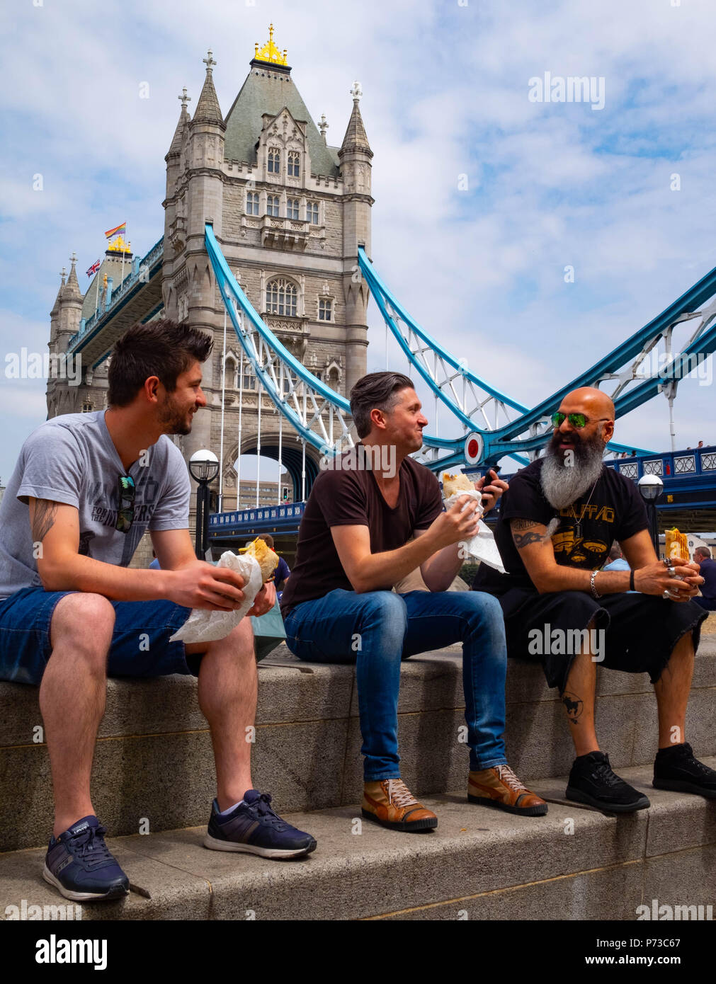 London, England. 4. Juli 2018. Klaus, und Mitul nehmen Zeit aus Ihren ereignisreichen Tag in ihrem Design Company Mittagessen an einem sehr heißen Tag in der Nähe von London, Tower Bridge zu essen. Die derzeitige Hitzewelle wird sich fortsetzen. © Tim Ring/Alamy leben Nachrichten Stockfoto