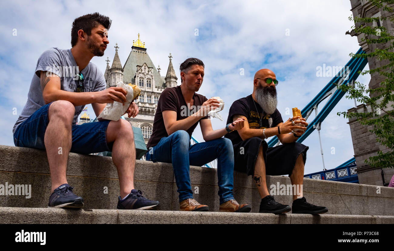 London, England. 4. Juli 2018. Klaus, und Mitul nehmen Zeit aus Ihren ereignisreichen Tag in ihrem Design Company Mittagessen an einem sehr heißen Tag in der Nähe von London, Tower Bridge zu essen. Die derzeitige Hitzewelle wird sich fortsetzen. © Tim Ring/Alamy leben Nachrichten Stockfoto