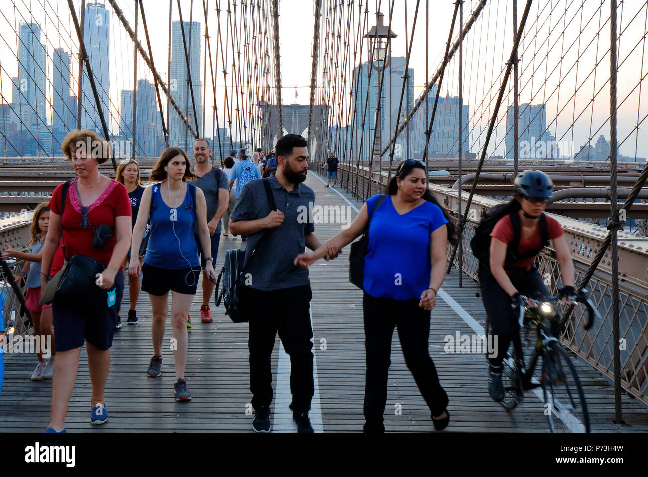 Fußgänger und Radfahrer vermeiden Konflikte auf dem Fußgängerweg der Brooklyn Bridge über den East River in New York, NY. Stockfoto