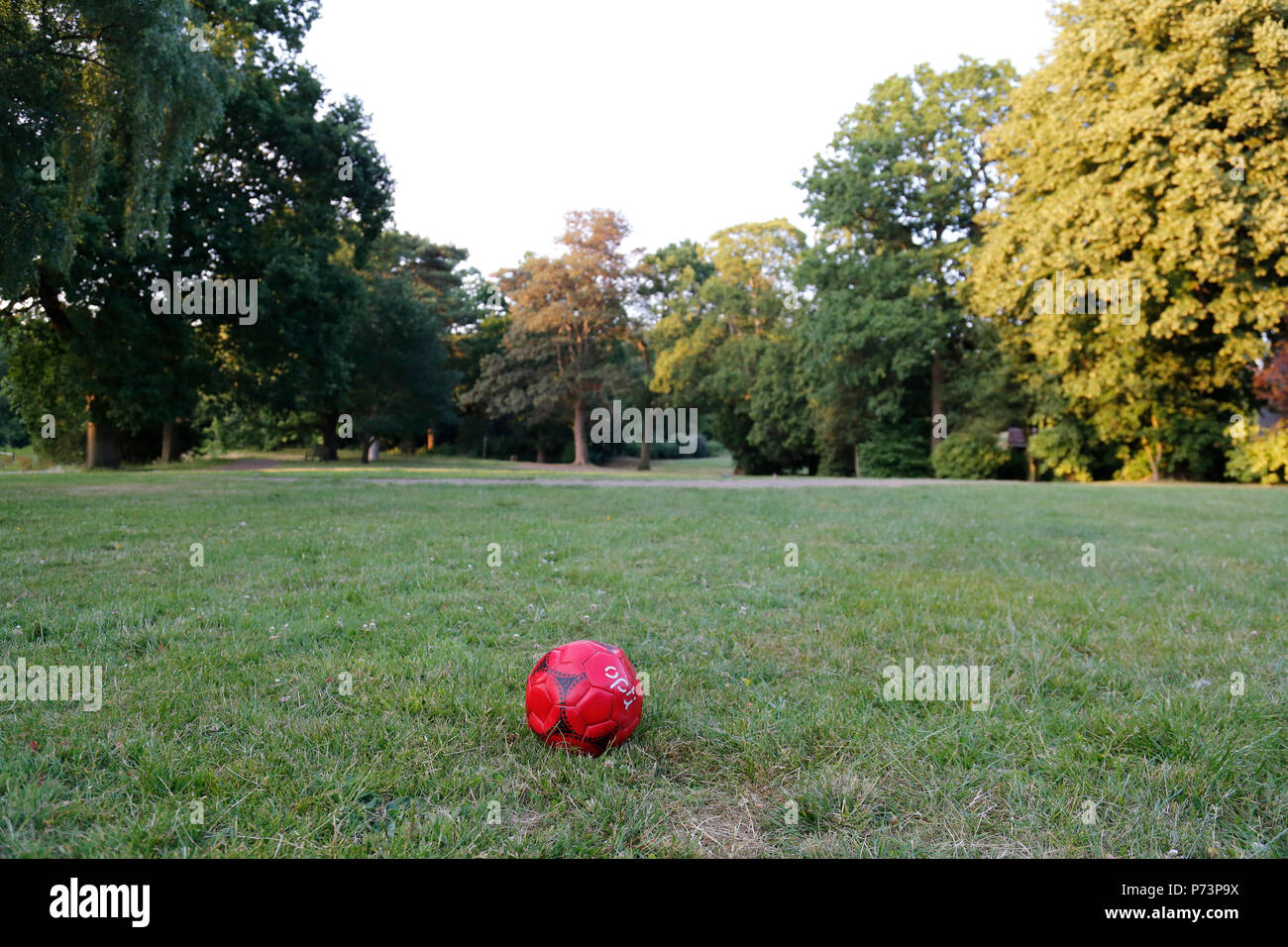 Deflationiert rot Fußball, im Park verworfen Stockfoto