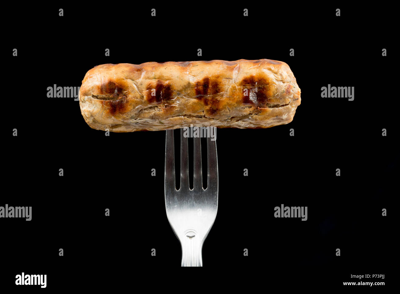 Eine vegane Quorn cumberland Wurst gekauft von einem Supermarkt, gegrillt wurde und auf einem schwarzen Hintergrund fotografiert. Großbritannien Stockfoto