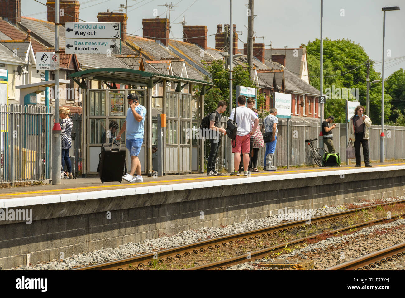Die Menschen warten auf einen Zug auf Gleis 1 des Rhoose Cardiff International Airport Bahnhof Stockfoto