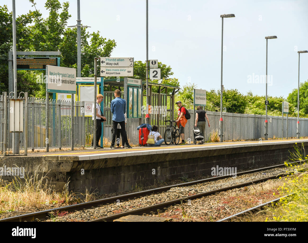 Die Menschen warten auf einen Zug auf Gleis 1 des Rhoose Cardiff International Airport Bahnhof Stockfoto