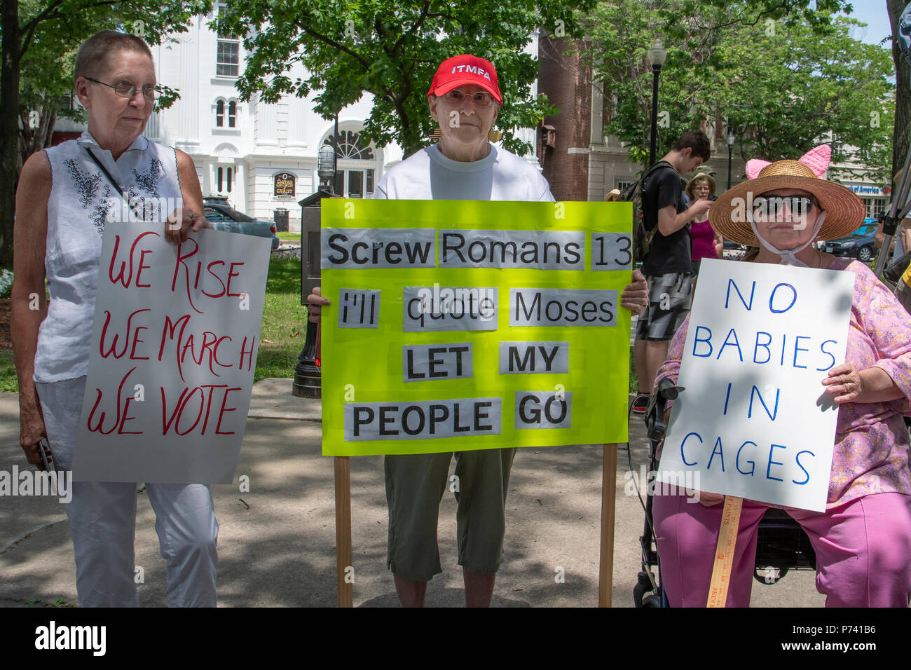 KEENE, NEW HAMPSHIRE/USA - 30. Juni 2018: drei Demonstranten halten Schilder auf einer Kundgebung gegen die Einwanderungspolitik der Trumpf-Verwaltung. Stockfoto