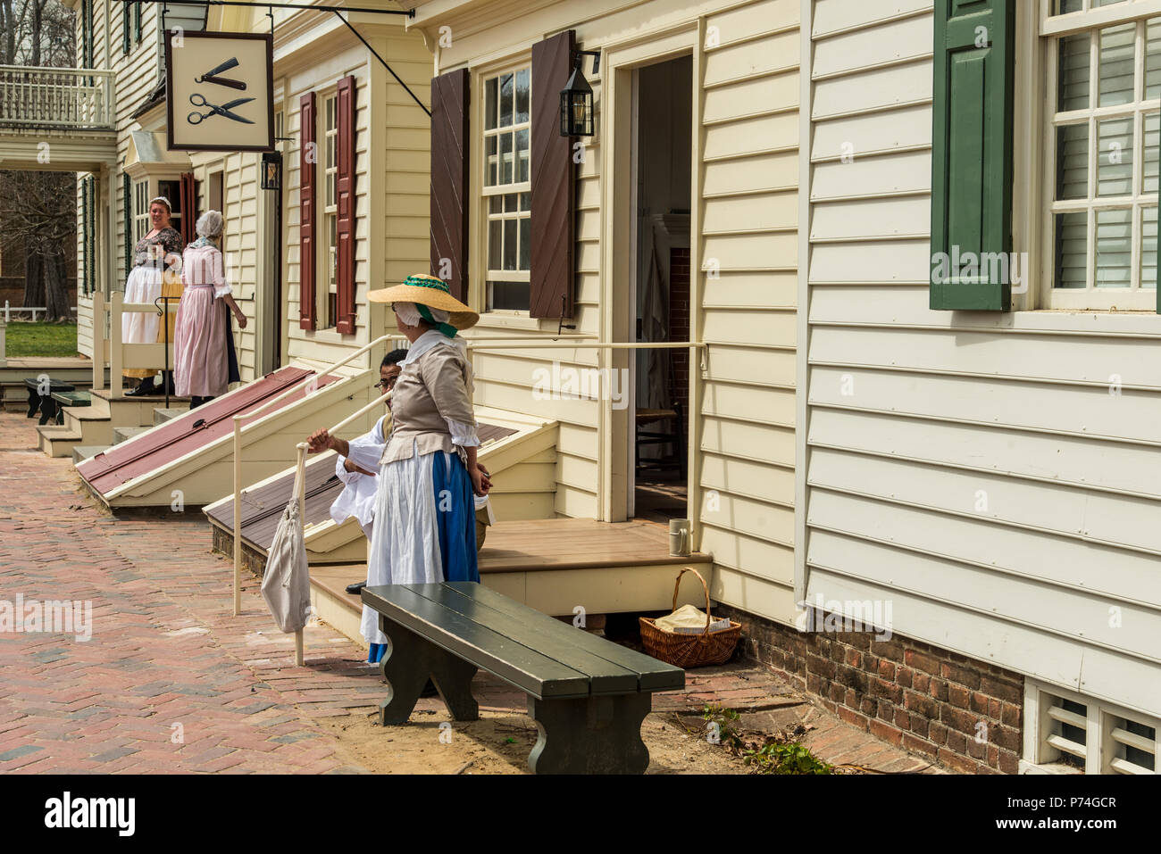 Williamsburg, Virginia, USA - April 1, 2018: Frau in historische Kleidung vor einem Haus gekleidet Stockfoto