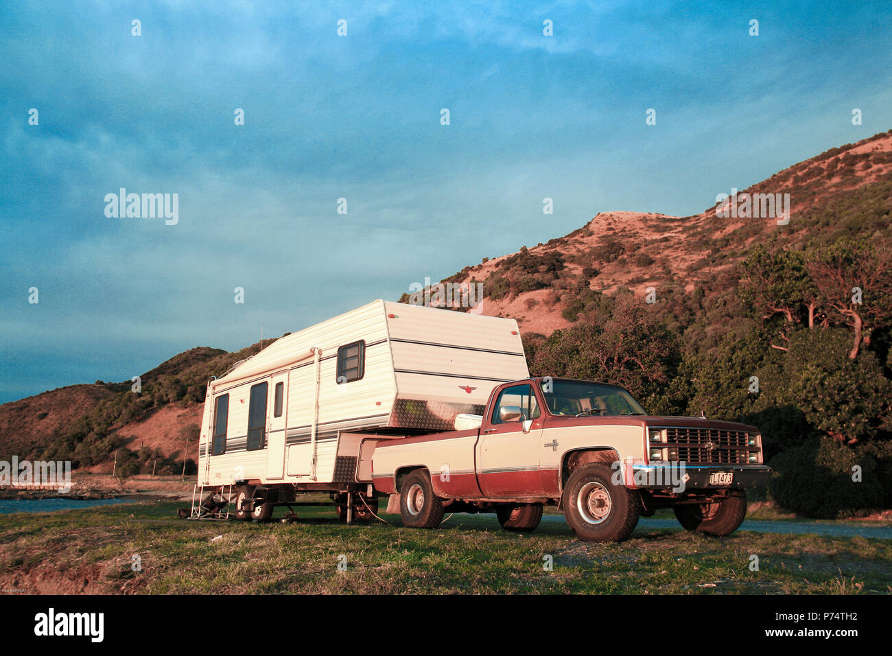Amerikanischer Pickup-Truck mit Wohnwagen, der auf dem Campingplatz an der Küste von Kaikoura, Neuseeland, geparkt ist Stockfoto