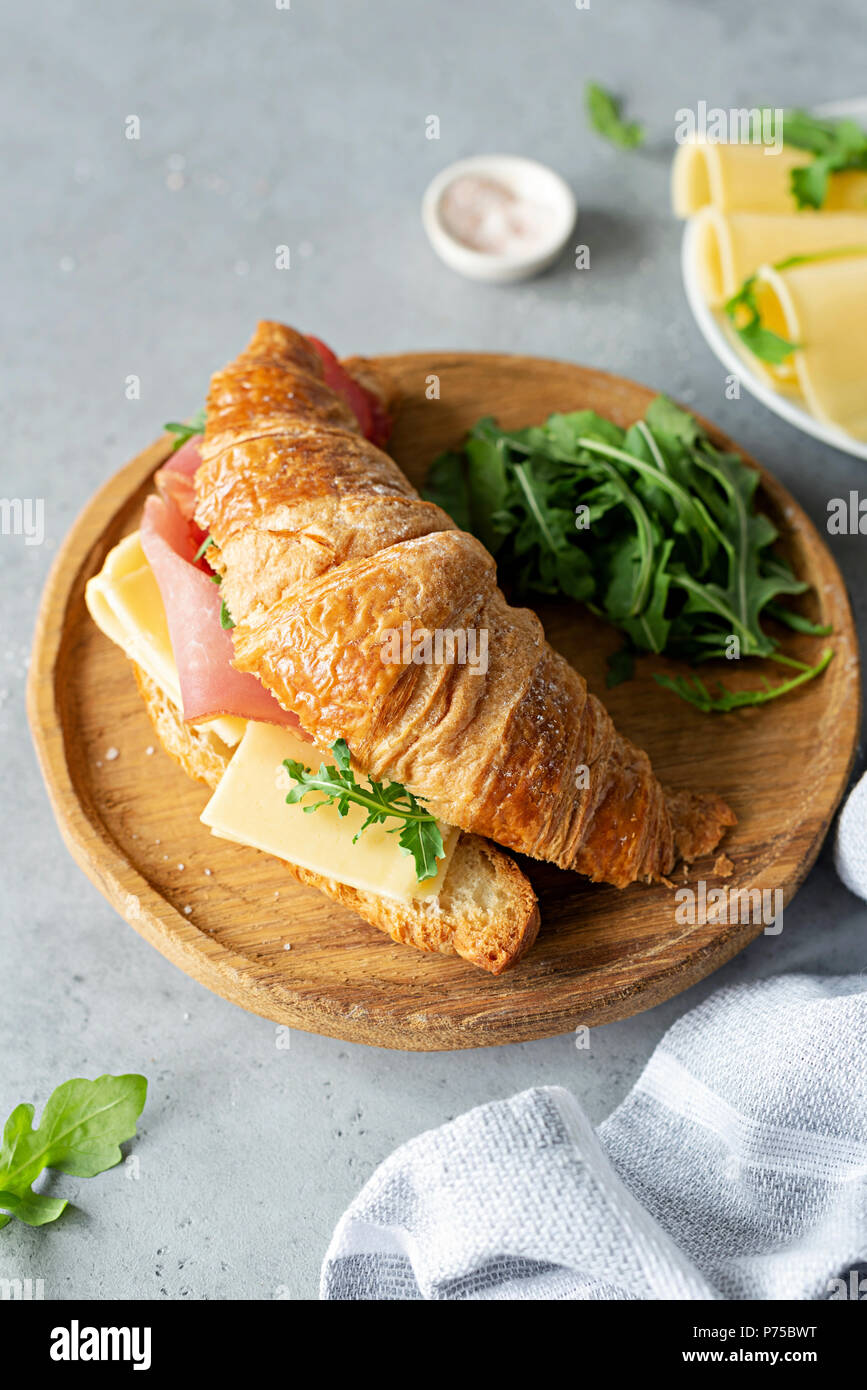 Leckere croissant Sandwich mit Schinken und Käse auf konkreten Hintergrund. Ansicht von oben. Breakfast Sandwich Stockfoto