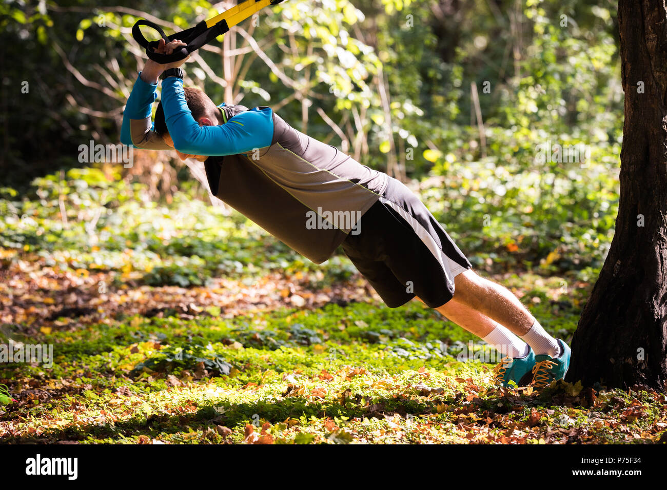 Hübscher junger Männer Sportkleidung tragen und trainieren in Wald am Berg im Herbst Stockfoto