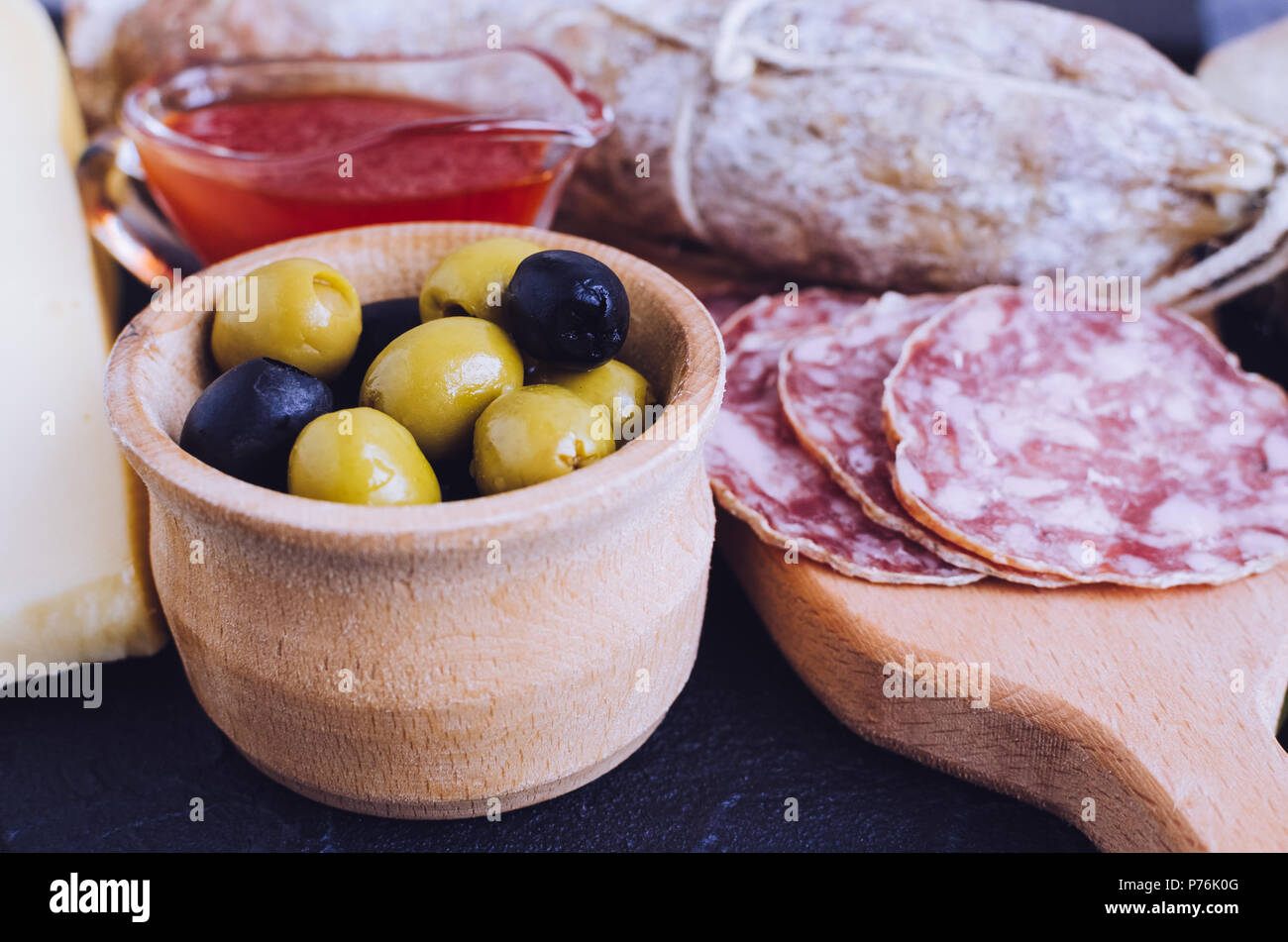 Mediterrane Vorspeisen, Tapas und Antipasti. Verschiedene italienische traditionelle Produkte essen. Leckerer Snack auf Party. Grüne und schwarze Oliven mit sa Stockfoto