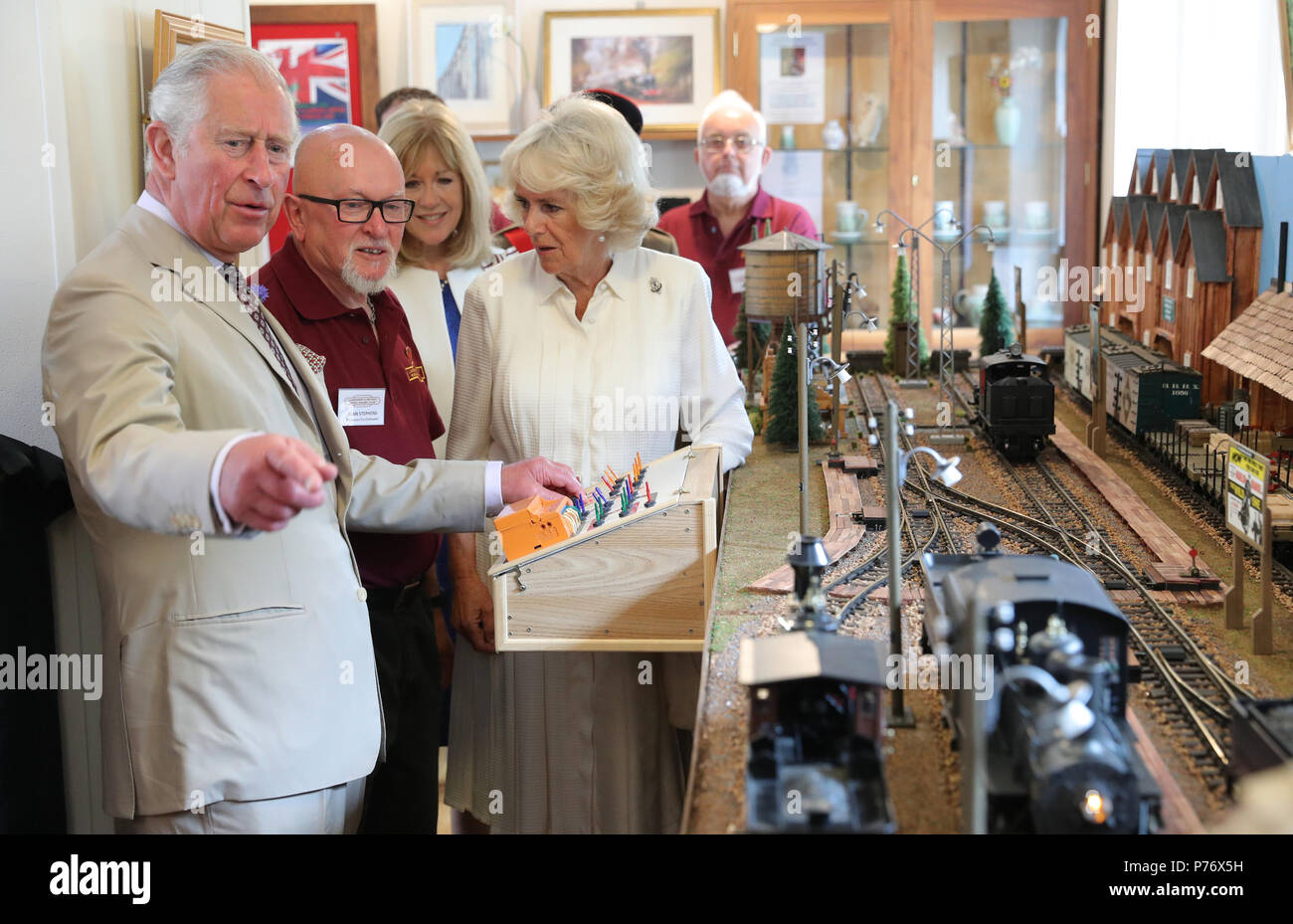 Der Prinz von Wales und die Herzogin von Cornwall versuchen, ein Modell bei einem Besuch in Kuusamo Bahnhof anläßlich des 150. Jahrestages der Herzen von Wales Bahnstrecke zu markieren. Stockfoto