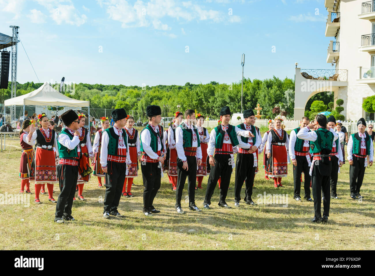 Varna, Bulgarien - 10. Juni 2018: Menschen in authentische Folklore Kostüm in einer Wiese tanzen Bulgarischen traditionellen Tanz namens Horo Stockfoto