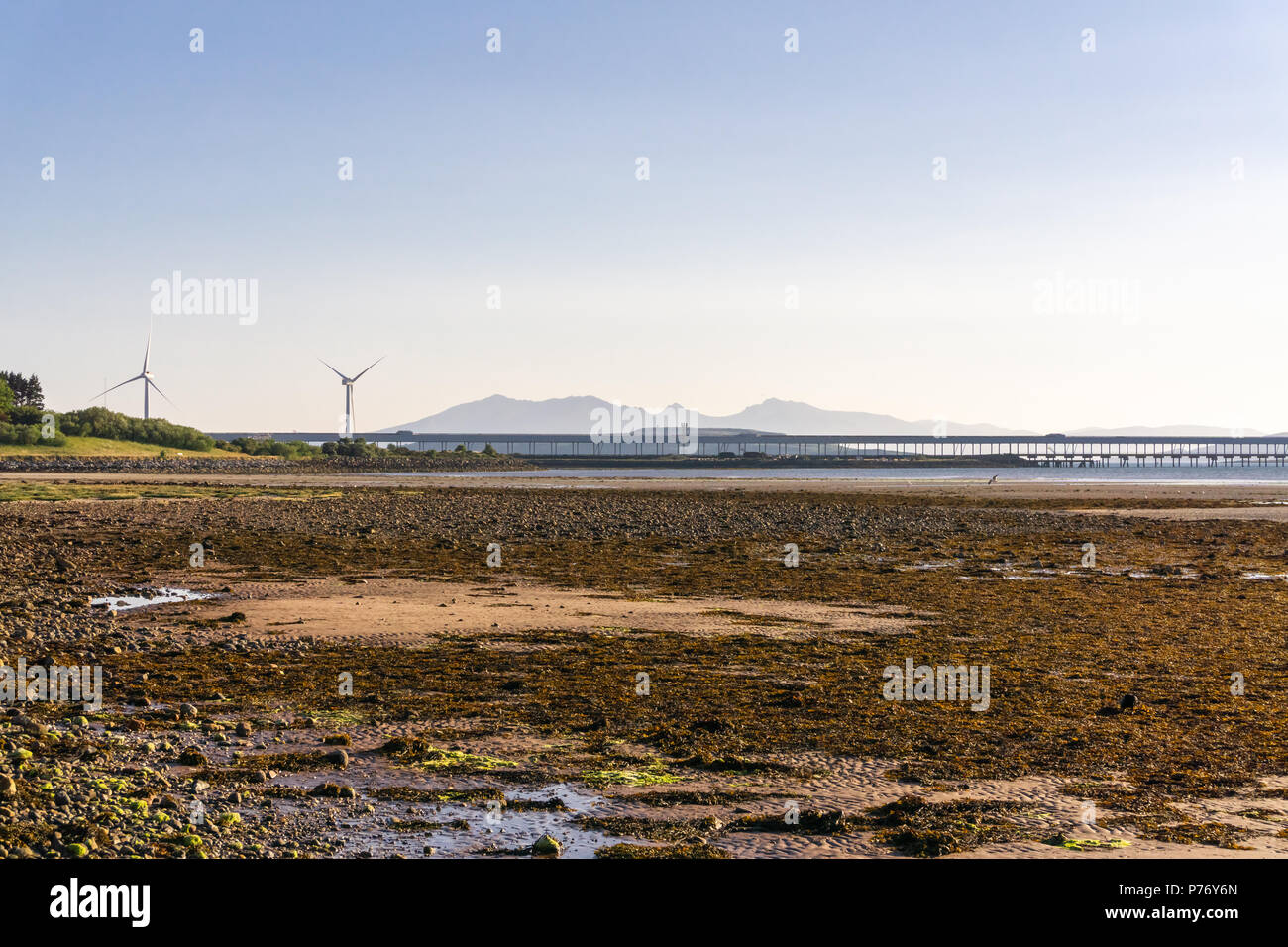 Von Fairlie Bay über Hunterston Jetty und die zwei riesigen windenergieanlagen. Arran ist in Silhouette in der dunstigen Hintergrund gesehen. Stockfoto