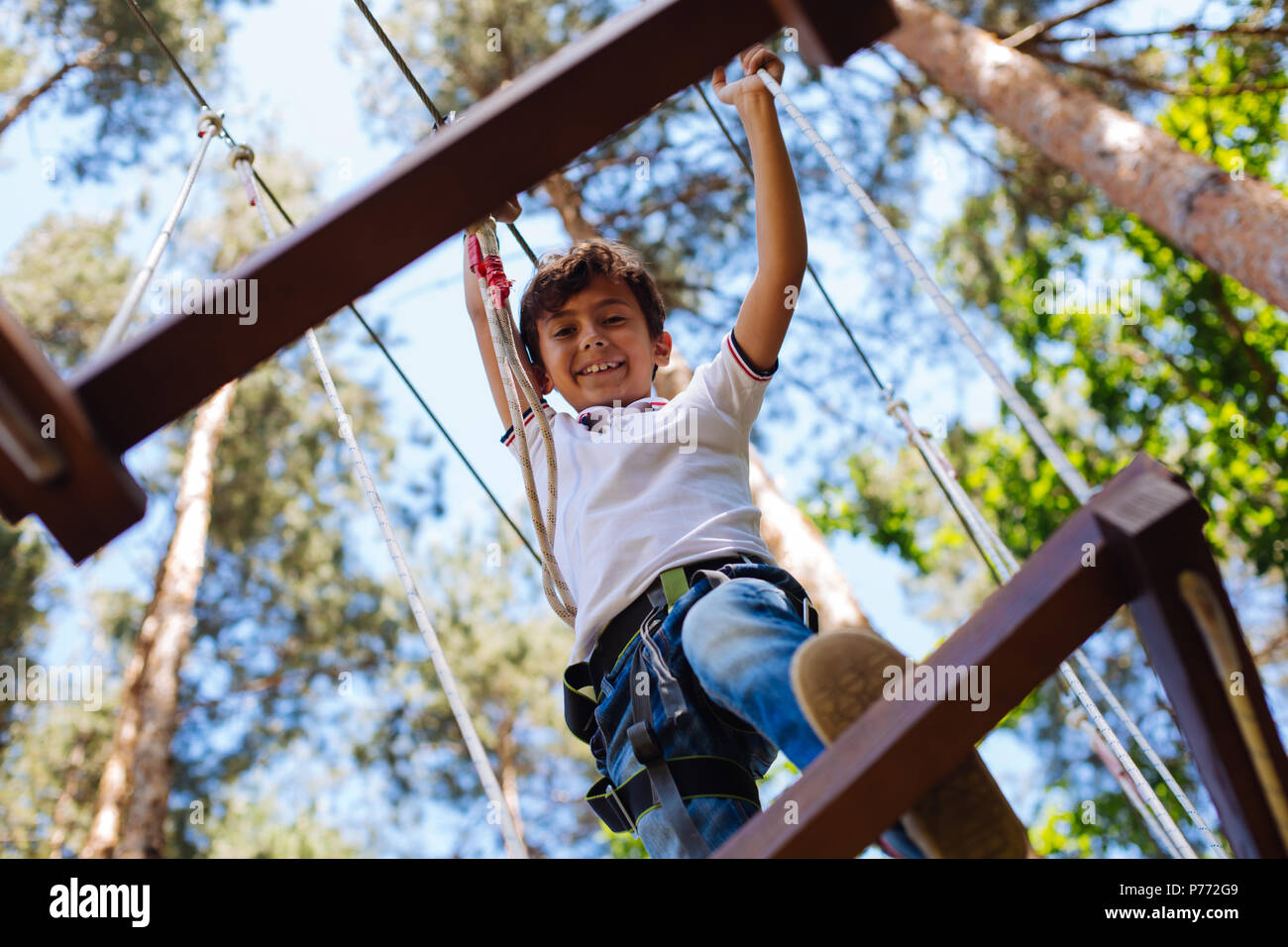 Cute Jugendliche junge Klettern im Abenteuerpark Stockfoto