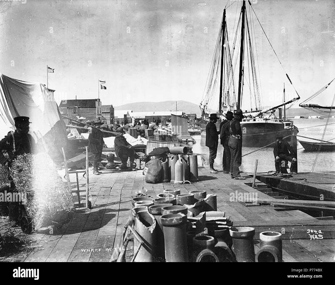 . Englisch: Männer und Fracht auf der Wharf auf Teller, Alaska, Ca. 1899. Englisch: Legende auf Bild: "Wharf am Teller 'Original Bild in Hegg Album 31, Seite 10. Original Foto von Eric A. Hegg 1170; von Webster und Stevens 304.A. kopiert Themen (LCTGM): Piers und Kaianlagen - Alaska - Erzähler; Versand - - Alaska - Teller Themen (LCSH): Erzähler (Alaska). ca. 1899 8 Männer- und Güterverkehr auf der Wharf auf Teller, Alaska, ca 1899 (HEGG 321) Stockfoto