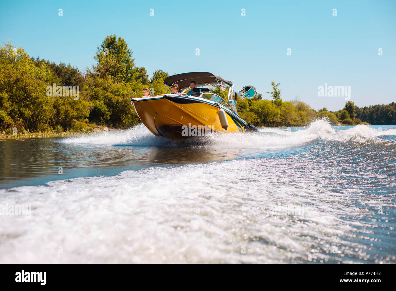 Angenehme junge Familie genießen Sie ein Motorboot fahren den Fluss hinunter Stockfoto