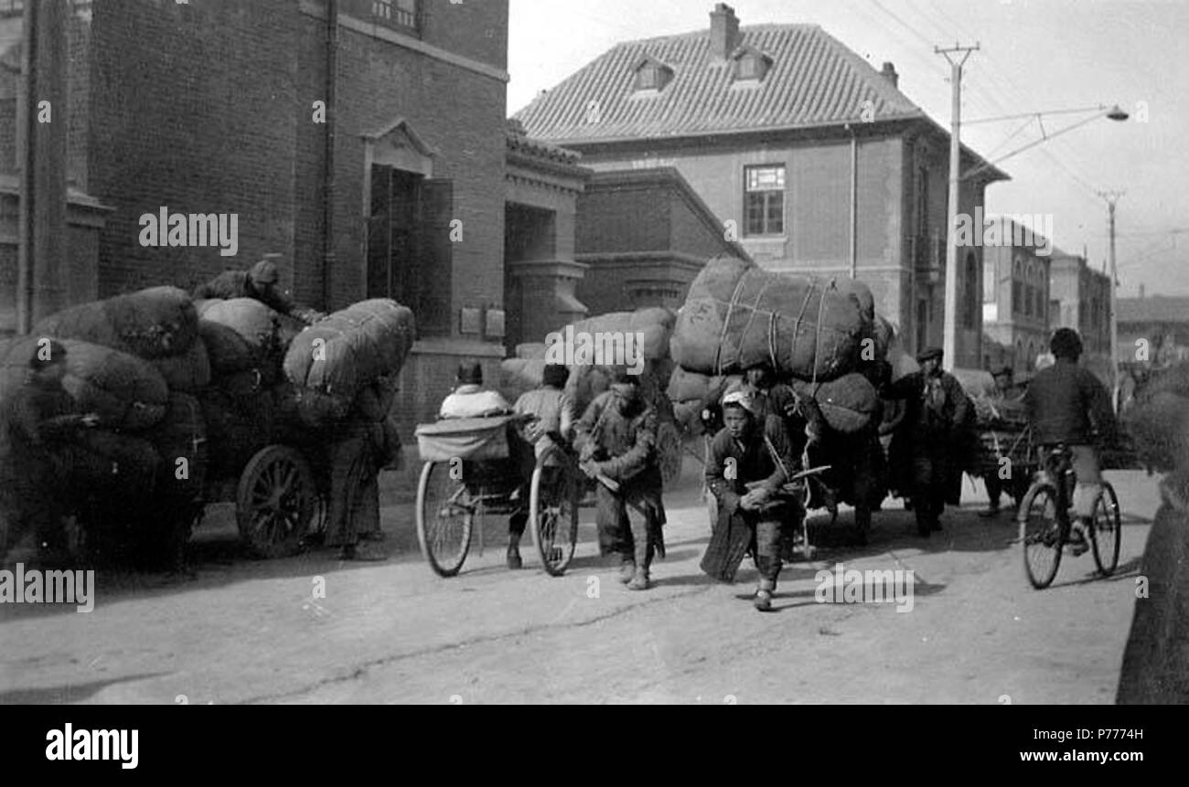 . Englisch: Schleppen Cargo durch Warenkorb aus Chandless Co., Tianjin, China, Ca. 1930. Englisch: Label auf der Rückseite: Tientsin, Ca. 1930. Schleppen Warenkorb der Ladung von Unternehmen Büros am Fluss/Schiene für den Versand. Ein Mann zieht und, wenn sehr schwere Ladung, einem anderen schiebt. PH-Coll 214.25 Themen (LCTGM): Arbeiter - China - Tianjin; Wolle Industrie - China - Tianjin; Versand - - China - Tianjin; Karren & Wagen - China - Tianjin; Fahrräder und Dreiräder - China - Tianjin, Rikschas - China - Tianjin Themen (LCSH): Chandless Firma (Tianjin, China); Tianjin (China) - Gebäude, Strukturen, etc. ca. 1930 5 Schleppen Cargo durch Warenkorb fr Stockfoto