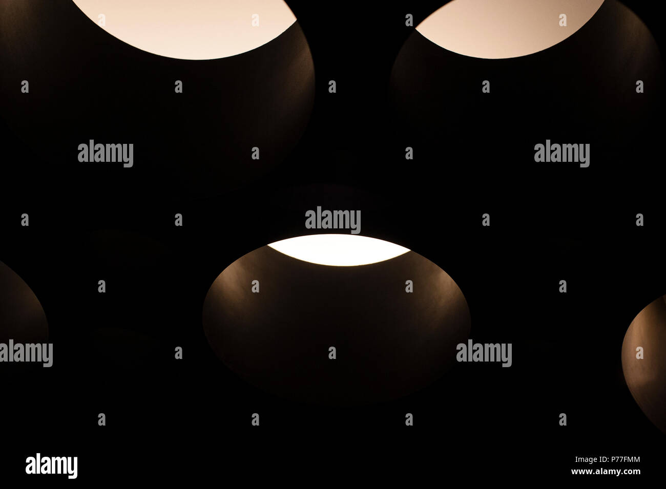 Runde orb Lichter in einer Gruppe in einem verdunkelten Raum. Stockfoto