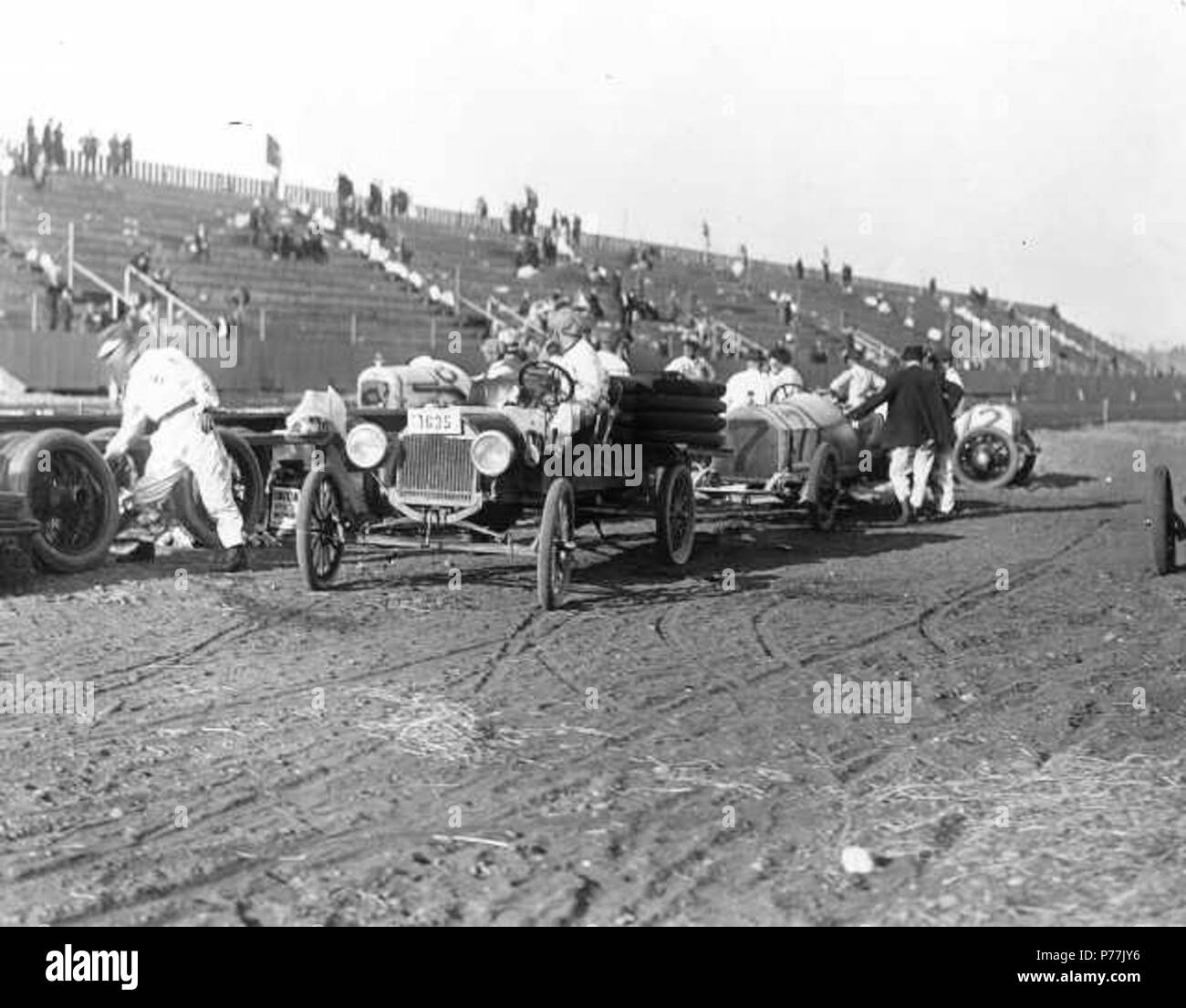 Englisch: Jim Parsons' #7 Frantz Rennwagen ist in der Grube in der Gegend von Tacoma Speedway ca. geparkt 1914 während ein Fahrzeug mit einer Last von Reifen langsam vor Es sichert. Andere Reifen bereits entladen haben, und sind aufrecht in der Nähe gestapelt. Die Tribünen sind fast leer, diese Praxis kann Zeit im Speedway wurden statt der tatsächlichen Juli Rennen. Jim Parsons, aus Seattle, würde der InterCity 100 Rennen in drei aufeinander folgenden Jahren, 1913-1915 zu gewinnen, die ihm den ewigen Wanderpokal zu halten. TPL -4424. Um 1914 13 Tacoma Speedway 1914 Pit - 39016 Stockfoto