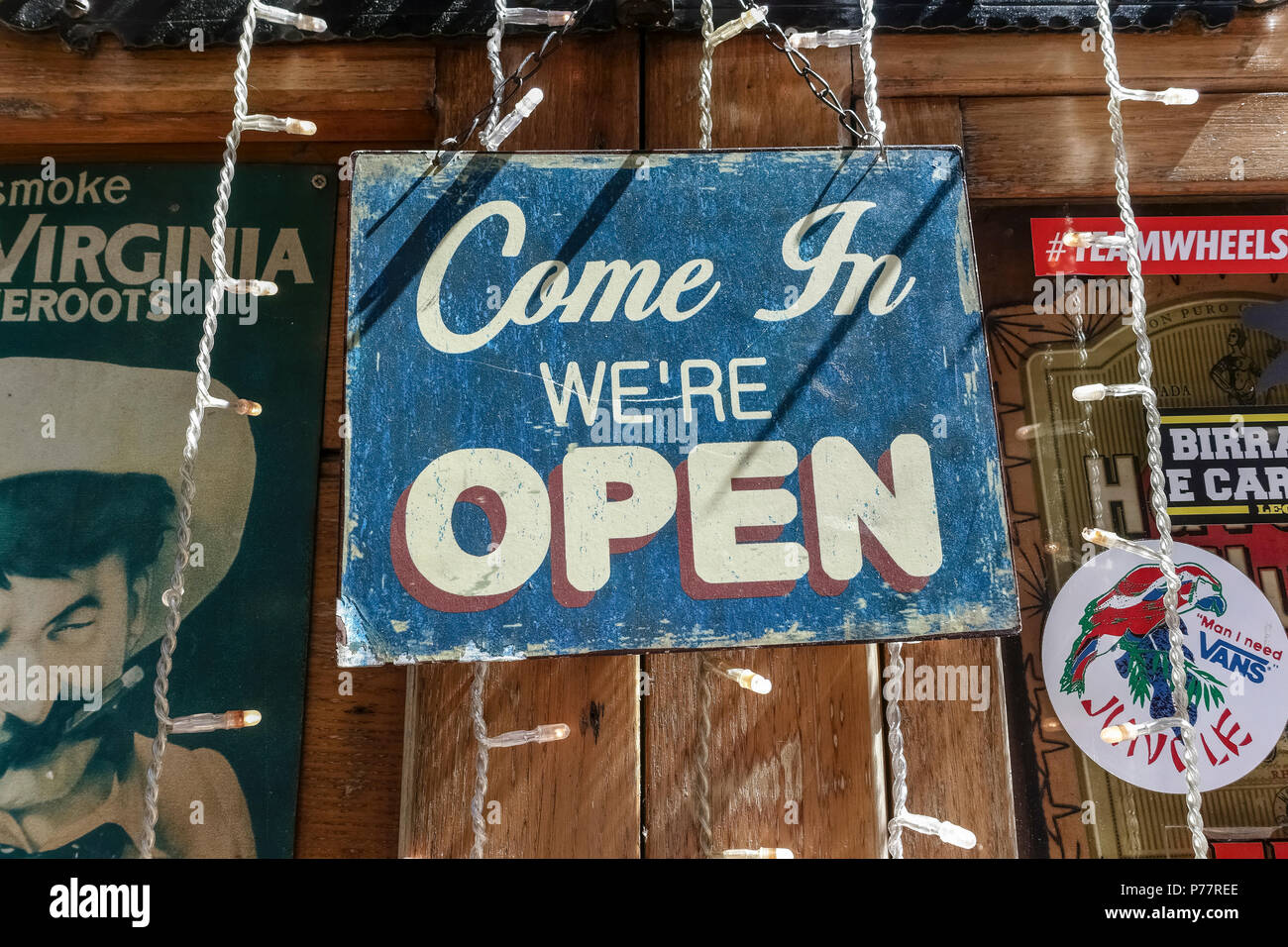 Altmodische, retro, Vintage" kommen wir öffnen' verblasst, scratch Schild hängen an einem Pub, Café Fenster. Close Up. Stockfoto