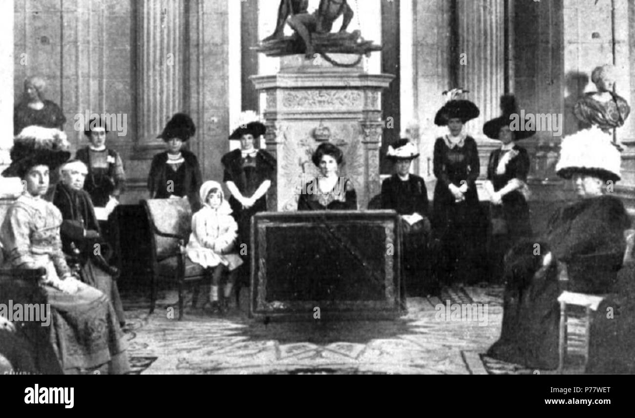 Español: Fotografía muestra que la Reina Victoria Eugenia de España presidiendo en el Salón de Columnas del Palacio Real un acto de Reparto de prendas caritativo del Ropero de Santa Victoria, Creado por Ella misma. Le acompañan Las Infantas, Isabel, María Teresa e Isabel Teresa. 2 Dezember 1911 55 Reina Victoria en el ropero 1911 Stockfoto