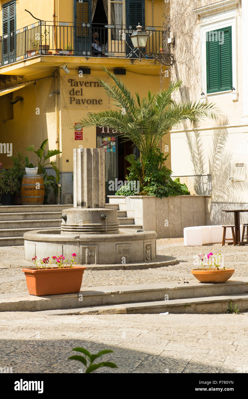 Italien Sizilien Balestrate Altstadt Straße Springbrunnen Pilar gepflasterten Platz Schritte treppen Taverna del Pavone Pflanzmaschinen Palm Tree Fensterläden Fass Stockfoto