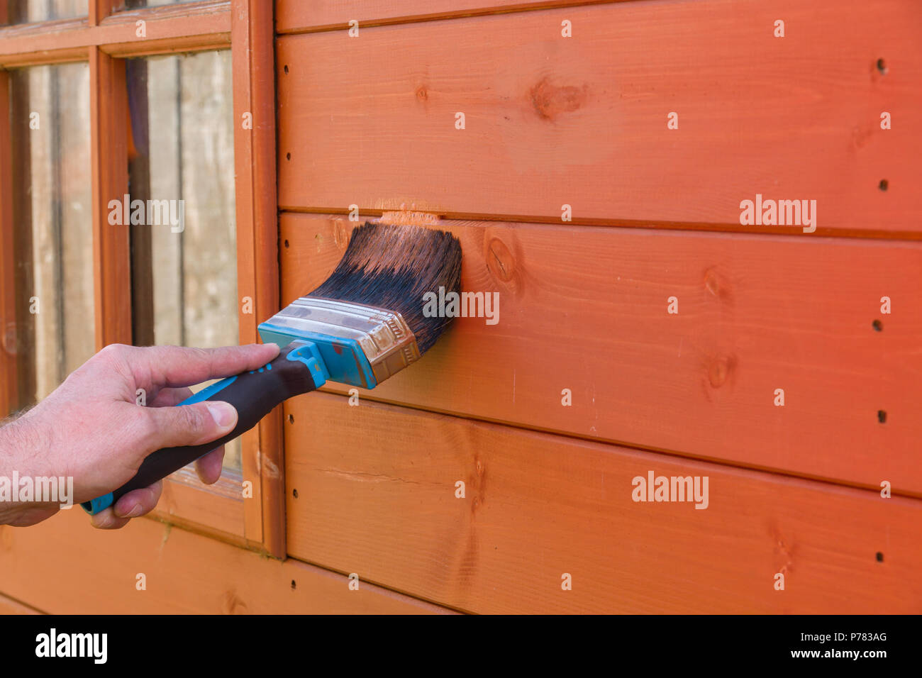 Malerei ein hölzernes Gartenhaus mit wasserdichten Holzschutzmittel es vor den Elementen zu schützen Stockfoto
