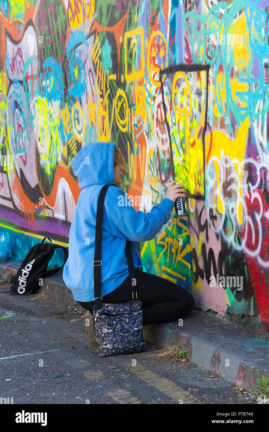 London Waterloo Leake Street Art College Group Schüler hübsches blondes  Mädchen blau hoodie Lernen graffiti Sprühfarbe Malerei abstrakte Handtasche  Straße bändigen Stockfotografie - Alamy