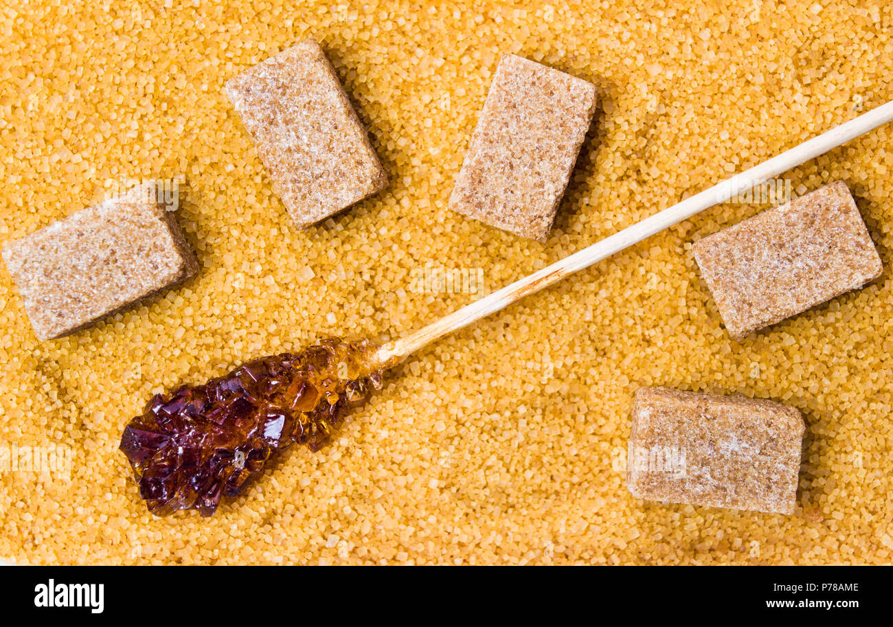 Brauner Zucker Sticks, Kristalle und Würfel Hintergrund der Ansicht von oben Stockfoto