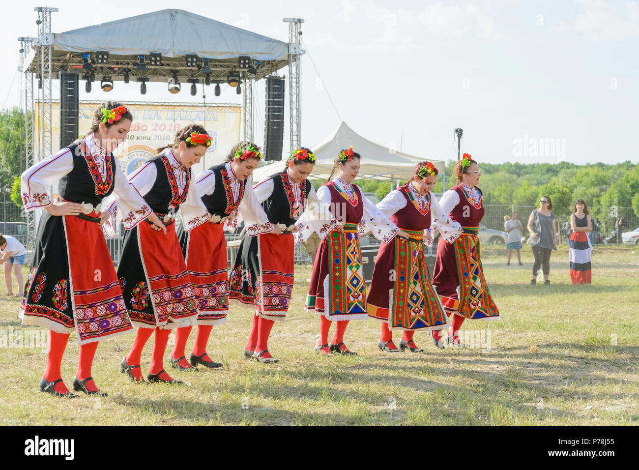 Varna, Bulgarien - 10. Juni 2018: Menschen in authentische Folklore Kostüm in einer Wiese tanzen Bulgarischen traditionellen Tanz namens Horo Stockfoto